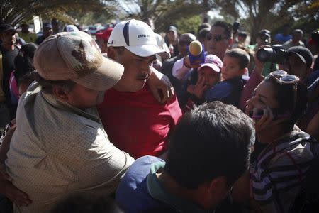 Vigilante leader Luis Antonio Torres, alias "El Americano" (C), is embraced by a supporter as he and other vigilantes voluntarily surrender to state authorities to cooperate in a shootout investigation in the town of Buenavista Tomatlan, Michoacan December 30, 2014. REUTERS/Alan Ortega