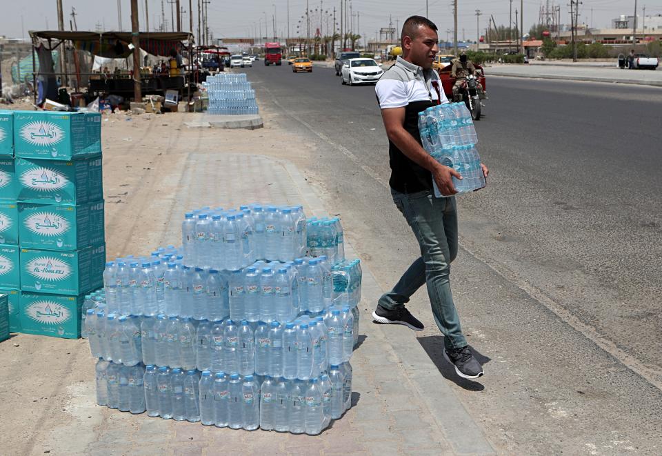 In this Sunday, July, 21, 2019, a man buys drinking water in Basra, southeast of Baghdad, Iraq. A leading rights group says Iraq's government is failing to properly address underlying causes for an ongoing water crisis in the country's south. A report released on Monday by Human Rights Watch on chronic water shortages and pollution in Iraq's Basra province says authorities continue to allow activities that pollute the province's water resources despite the health risks to residents. (AP Photo/Nabil al-Jurani)
