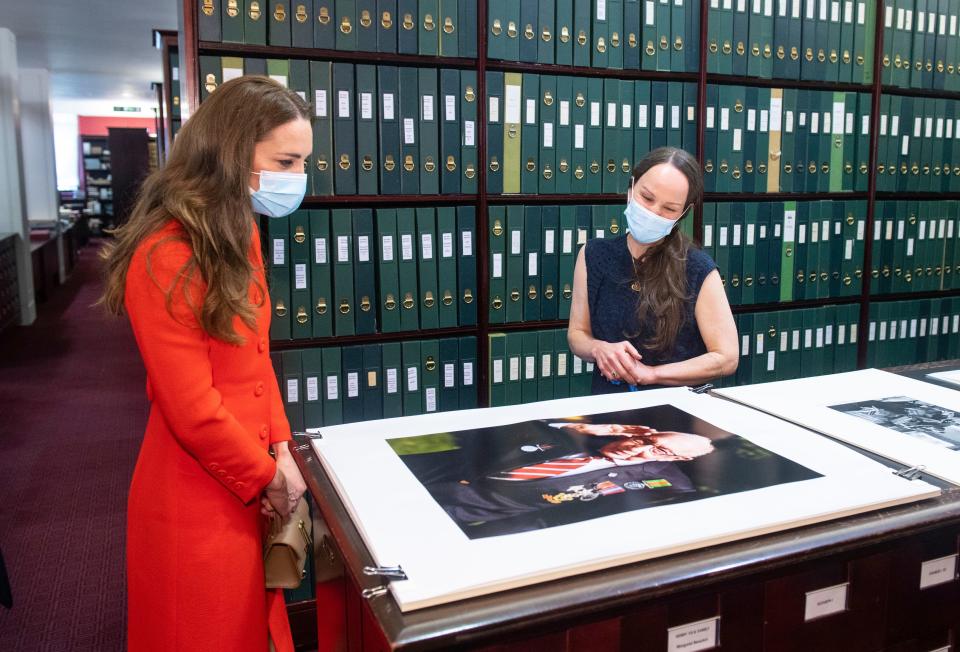 Duchess Kate of Cambridge views a photo of Captain Tom Moore alongside curator Magda Keaney during a visit to the archive in the National Portrait Gallery in London, May 7, 2021 to mark the publication of the book "Hold Still."