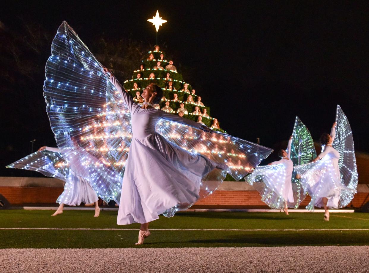 Dancers dressed as angels perform in front of the Belhaven Concert Choir at Jackson's annual Singing Christmas Tree at Belhaven's Bowl Stadium in Jackson on Friday, Dec. 2, 2022.