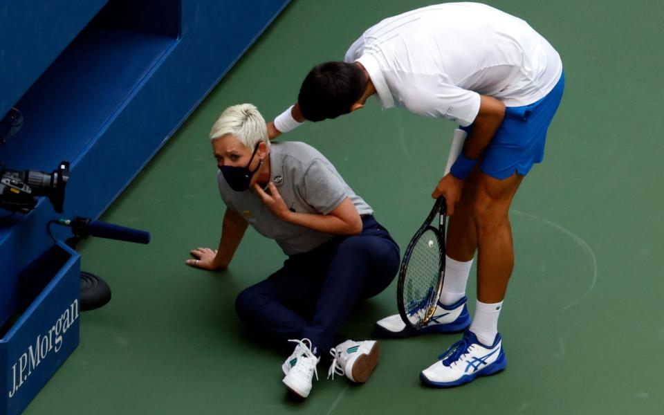 Novak Djokovic of Serbia (R) tries to help a linesperson after hitting her with a ball in the throat during his match against Pablo Carreno Busta  - Shutterstock