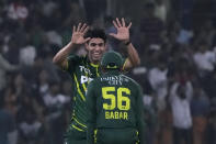 Pakistan's Abbas Afridi, without cap, celebrates with teammate after taking the wicket of New Zealand's Josh Clarkson during the fourth T20 international cricket match between Pakistan and New Zealand, in Lahore, Pakistan, Thursday, April 25, 2024. (AP Photo/K.M. Chaudary)