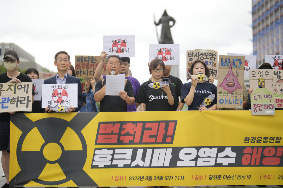 Members of an environmental group hold signs during a rally to demand the stop of the Japanese government's decision to release treated radioactive water into the sea from the damaged Fukushima nuclear power plant, in Seoul, South Korea, Thursday, Aug. 24, 2023. The letters read " Stop to release radioactive water." (AP Photo/Lee Jin-man)