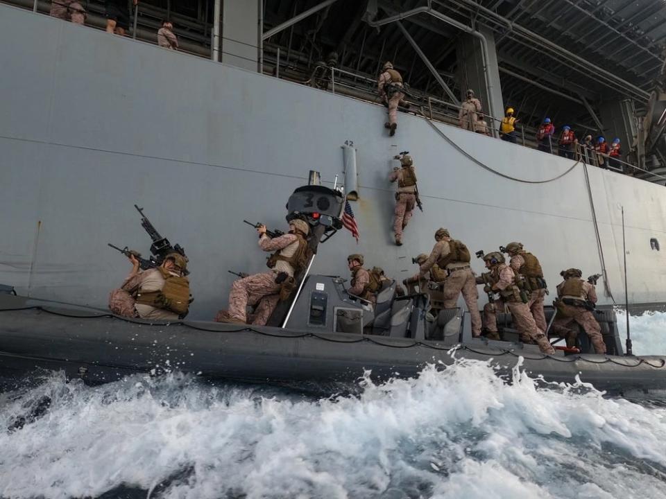 US Marines board expeditionary sea base USS Lewis B. Puller from inflatable boat