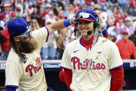 Philadelphia Phillies' Alec Bohm, right, is doused by teammates Brandon Marsh, left, and Bryson Stott during an interview after the team's baseball game against the Atlanta Braves, Sunday, March 31, 2024, in Philadelphia. (AP Photo/Derik Hamilton)