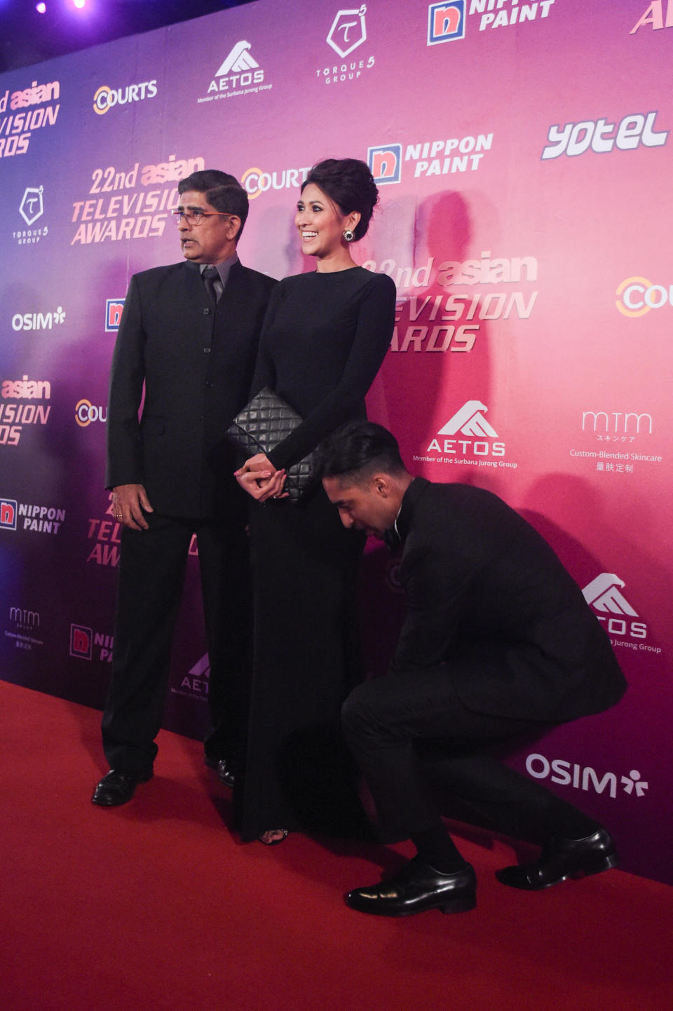 <p>Actor J. Jai Kishan helps actress Nurul Aini with her dress as they pose for photos on the red carpet with veteran actor R. Chandran at the 22nd Asian Television Awards. (Photo: Joseph Nair for Yahoo Lifestyle Singapore) </p>