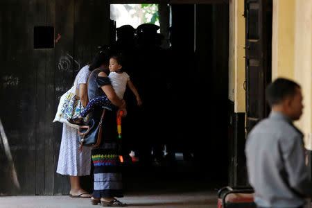 Moe Thin Wai Zin, daughter of detained Reuters journalist Kyaw Soe Oo, is carried by her mother as they arrive for a court hearing in Yangon, Myanmar April 20, 2018 . REUTERS/Ann Wang