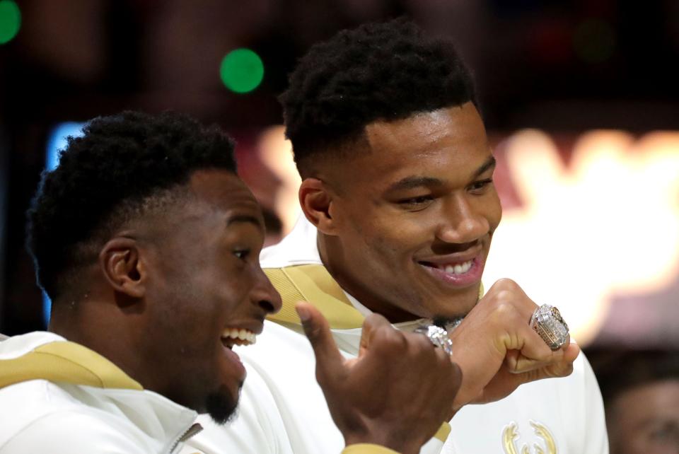 Milwaukee Bucks forward Giannis Antetokounmpo, right, and his brother, Bucks forward Thanasis Antetokounmpo, show off their championship rings during the Bucks ring ceremony before the season opener vs. the Brooklyn Nets at Fiserv Forum in Milwaukee on Oct. 19, 2021.