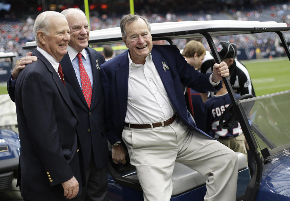 Former President George H. W. Bush, right, former Secretary of State James Baker, left, and Houston Texans owner Bob McNair pose together before an NFL football game against the Buffalo Bills Sunday, Nov. 4, 2012, in Houston. (AP Photo/Eric Gay)