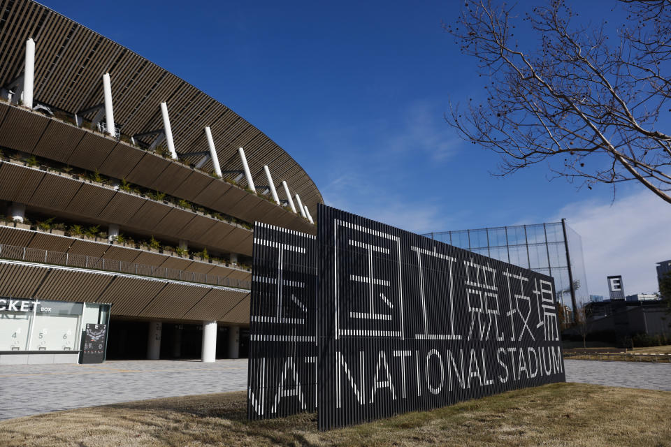 Stadium signs stand outside the new National Stadium Sunday, Dec. 15, 2019, in Tokyo. The stadium is officially completed. (AP Photo/Jae C. Hong)