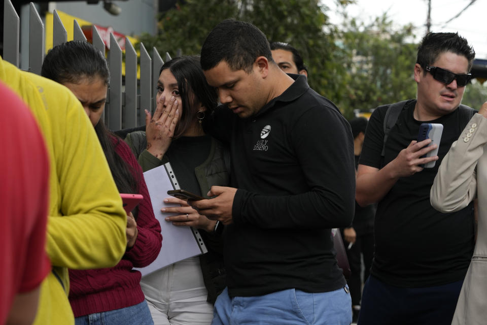 Personas aguardan en el exterior de la embajada de Venezuela en Quito, Ecuador, el martes 16 de abril de 2024. El presidente venezolano, Nicolás Maduro, ordenó el cierre de la embajada y de los consulados de su país en Ecuador en solidaridad con México y como rechazo a la irrupción de la policía ecuatoriana en la embajada de México en Quito. (AP Foto/Dolores Ochoa)