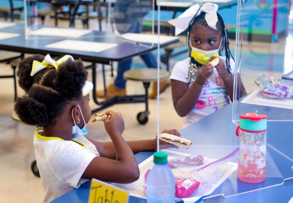 Pre-K students Kahli Pinckney and Madison Smith eat lunch on Wednesday, Aug. 18, 2021, the first day of school at A.C. Moore Elementary School.