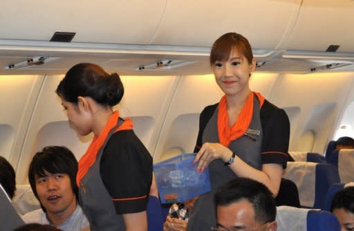 Transsexual fight attendant Chayathisa Nakmai (right) works onboard a Thai PC Air flight between Bangkok and Hong Kong on March 9. Fledgling Thailand-based carrier PC Air has hired four transgender cabin crew in a highly publicised recruitment drive that has divided opinion over whether the move is in the spirit of equality or exploitation