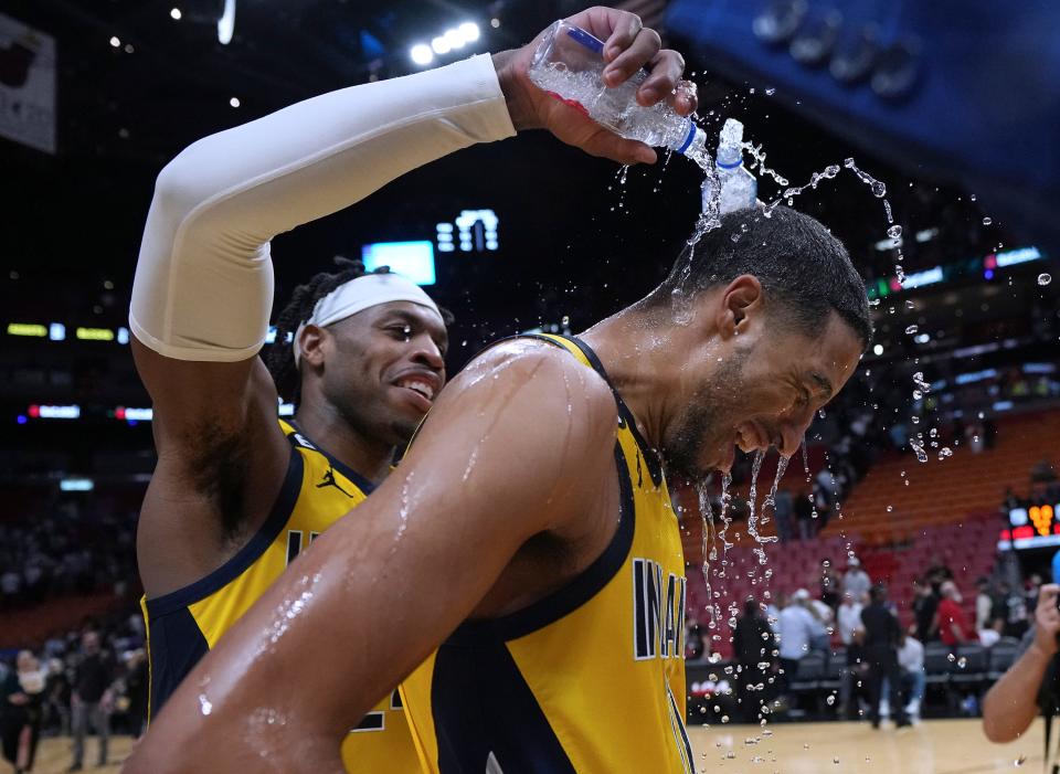 Indiana Pacers guard Buddy Hield, left, douses guard Tyrese Haliburton after the team's 111-108 victory over the Miami Heat on Dec. 23, 2022, in Miami. Haliburton, who scored a career-high 43 points, hit the game-winning 3-pointer in the closing seconds. He finished 10 of 16 from beyond the arc.