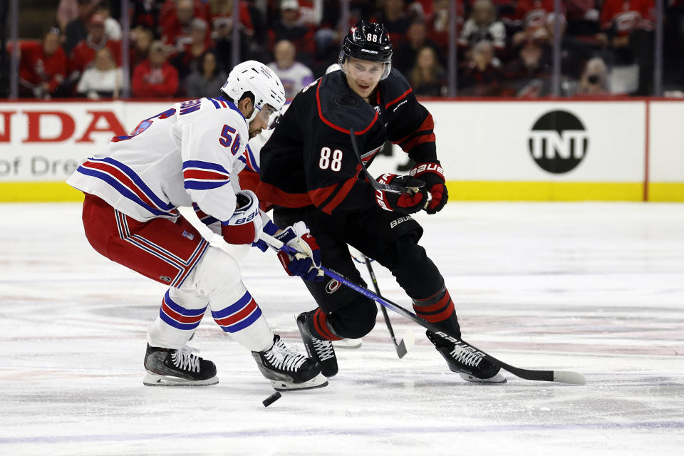 Carolina Hurricanes' Martin Necas (88) chases the puck with New York Rangers' Erik Gustafsson (56) during the second period in Game 4 of an NHL hockey Stanley Cup second-round playoff series in Raleigh, N.C., Saturday, May 11, 2024. (AP Photo/Karl B DeBlaker)