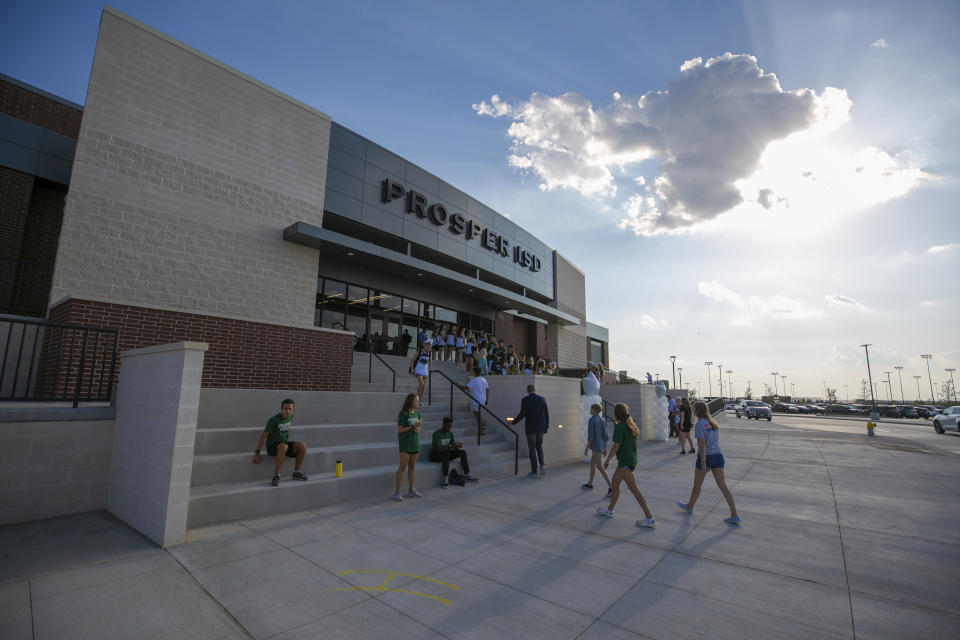 People walk to the entrance during the opening of the new Children's Health Stadium at Prosper ISD on Saturday, Aug. 17, 2019, in Prosper, Texas. Democrats are out to show they’re serious about flipping Texas in 2020 by holding Thursday’s presidential debate in Houston. Republicans are coming off their worst election in Texas in a generation. Fast-changing suburbs are trending more liberal, and Democrats are counting on more left-leaning voters moving in to turn the state blue. But that transformation may not arrive by 2020, and the GOP is closely watching conservative bastions like the booming Dallas suburbs. (AP Photo/Nathan Hunsinger)