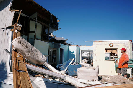 A man stands in the living room of his house with no roof following Hurricane Michael in Mexico Beach, Florida, U.S., October 13, 2018. REUTERS/Carlo Allegri