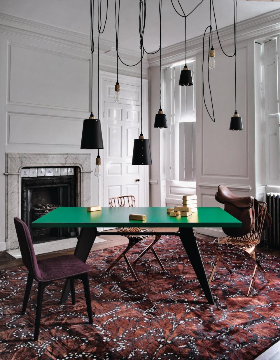 A dining room with a bold green table