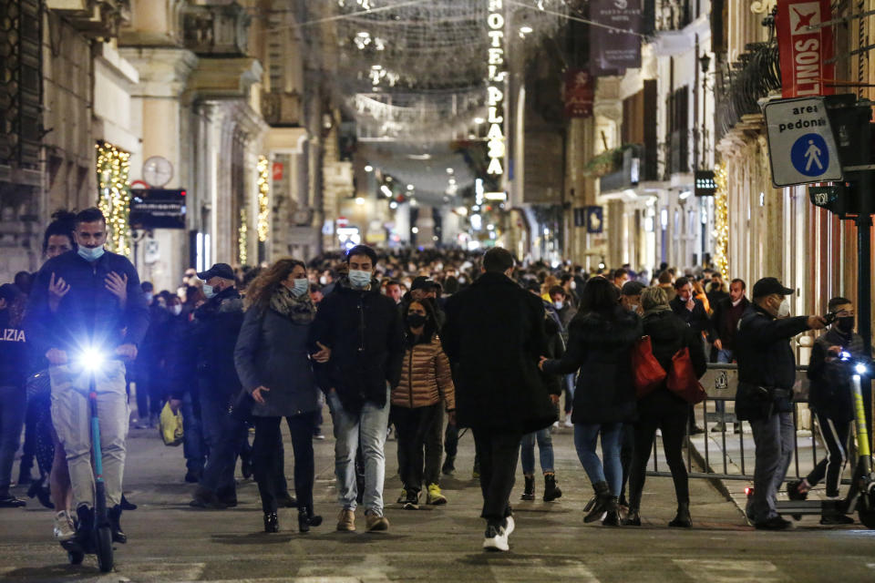 People stroll in Via del Corso shopping street, downtown Rome, Saturday, Dec. 5, 2020. Earlier in the week, Italy’s Premier Giuseppe Conte signed a decree sharply limiting travel between regions on Dec. 21 till after the Jan. 6 national Epiphany Day holiday. (Cecilia Fabiano/LaPresse via AP)