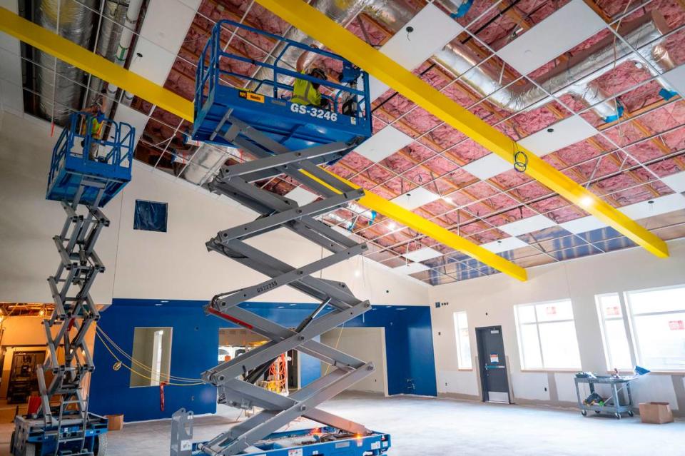 Workers use lifts as they install ceiling panels in the multi-purpose gymnasium at the new Fawcett Elementary School on Friday, March 3, 2023, in Tacoma.