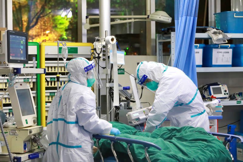 Medical staff in protective suits treat a patient with pneumonia caused by the new coronavirus at the Zhongnan Hospital of Wuhan University, in Wuhan