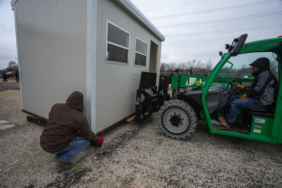 Antonio Flores and JoJo Ledezma help place a cabin with a forklift at Camp Esperanza. Travis County on Tuesday approved a $3 million contract with the Other Ones Foundation for the Camp Esperanza Shelter Complex.