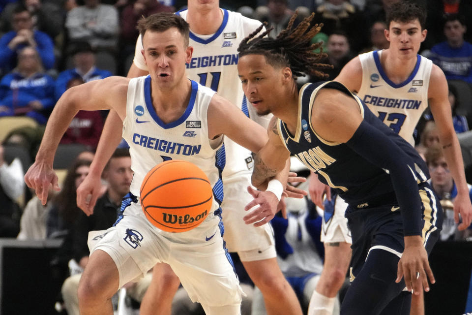 Akron’s Shammah Scott, right, and Creighton’s Steven Ashworth battle for a loose ball during the first half of a college basketball game in the first round of the NCAA men’s tournament in Pittsburgh, Thursday, March 21, 2024. (AP Photo/Gene J. Puskar)