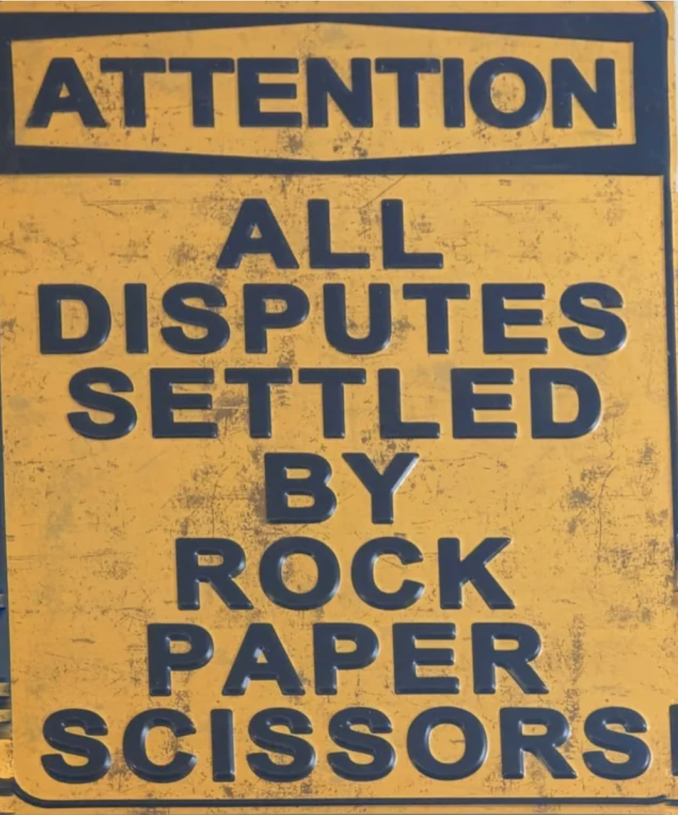 Sign: "Attention: All disputes settled by rock paper scissors!"