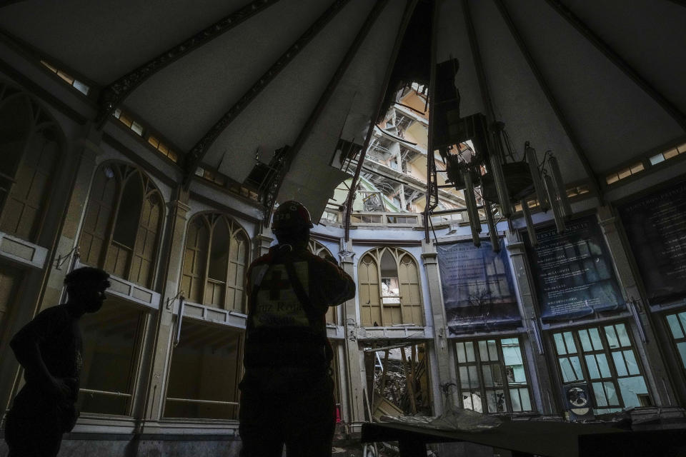 A member of the Cuban Red Cross takes pictures inside the Calvary Baptist Church, damaged by an explosion that devastated Havana's Hotel Saratoga, in Old Havana, Cuba, Wednesday, May 11, 2022. Church officials say that fortunately, none of the people inside were hurt in the May 6 explosion. (AP Photo/Ramon Espinosa)