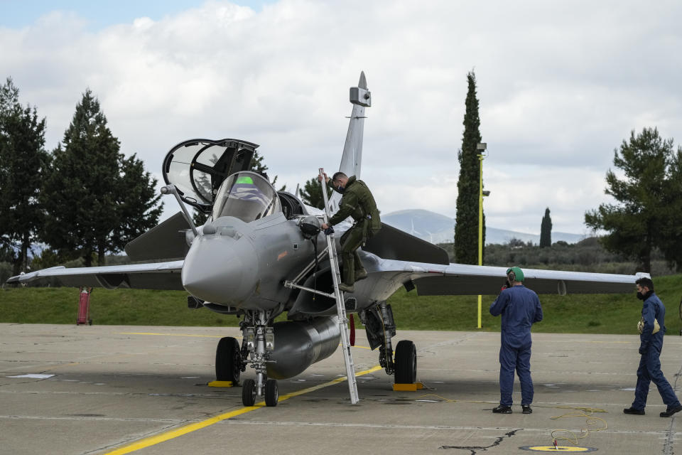 A Greek airforce pilot gets down from a Rafale jet during a hand over ceremony in Tanagra military air base, about 82 kilometres (51miles) north of Athens, Greece, on Wednesday, Jan. 19, 2021. Six advanced-tech Rafale jets bought from the French air force were handed over Wednesday to the Greek armed forces ‒ the first major delivery to result from multi-billion euro defense deals sealed with Paris last year. (AP Photo/Thanassis Stavrakis)