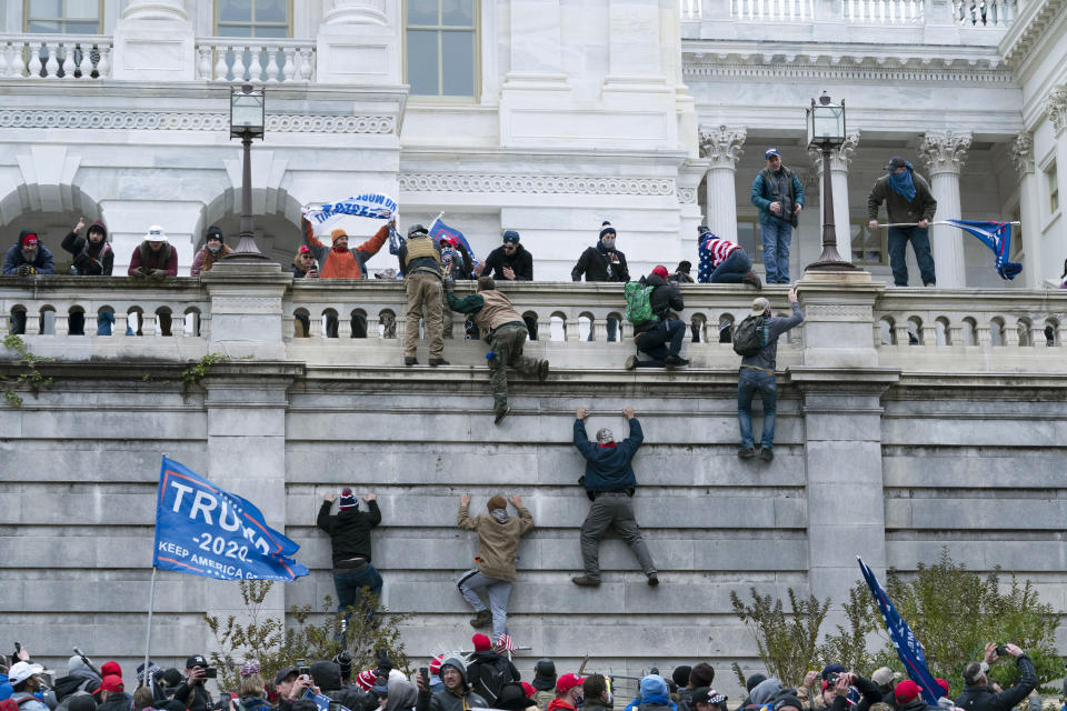 FILE - In this Jan. 6, 2021 file photo, violent insurrectionists loyal to President Donald Trump scale the west wall of the the U.S. Capitol in Washington. In the nearly nine months since Jan. 6, federal agents have managed to track down and arrest more than 600 people across the U.S. believed to have joined in the riot at the Capitol. Getting those cases swiftly to trial is turning out to be an even more difficult task. (AP Photo/Jose Luis Magana, File)