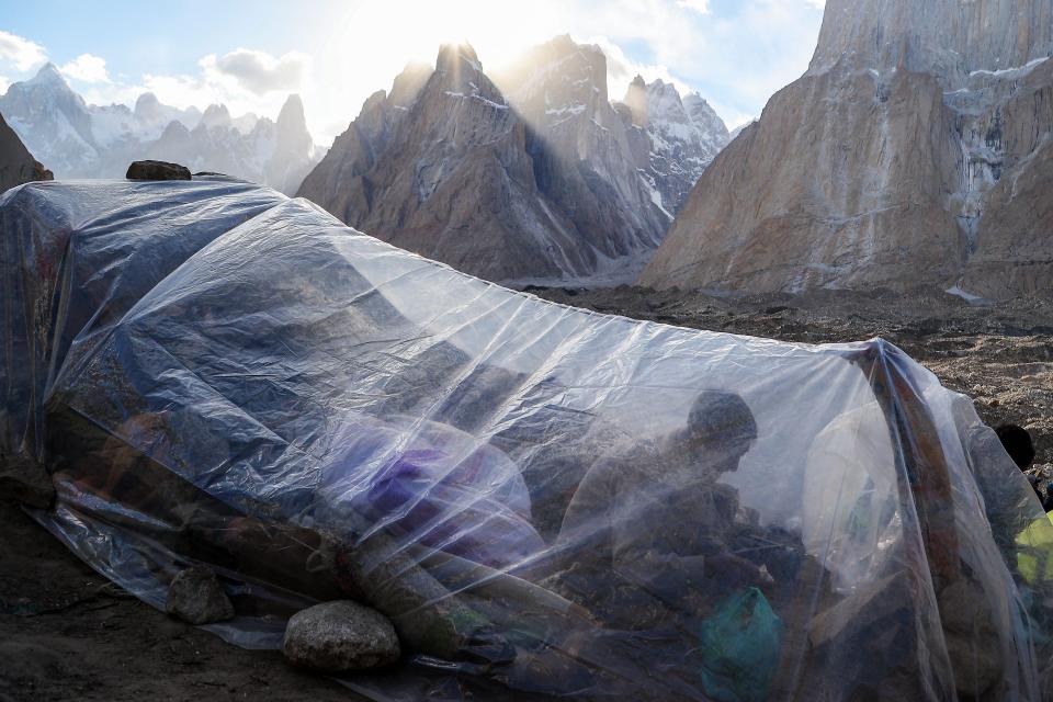 A porter rests under a sheet of plastic.