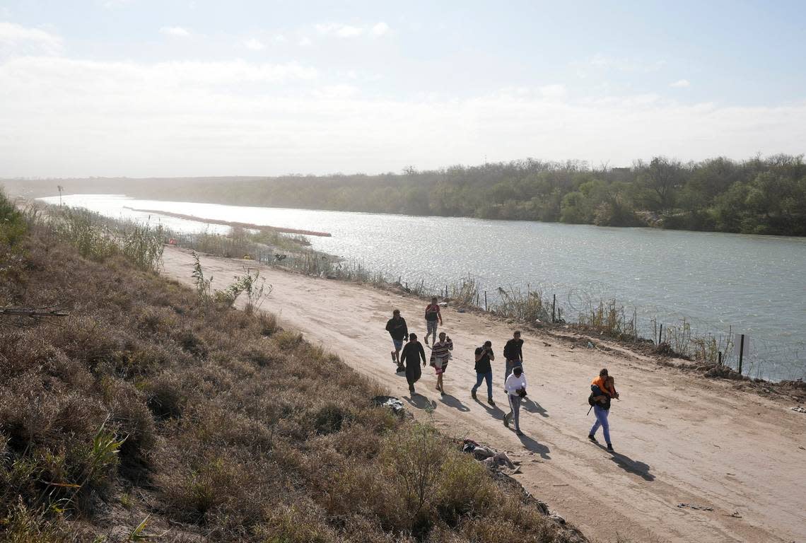 A group of migrants from Venezuela walk along the banks of the Rio Grande to surrender to U.S. Border Patrol after they entered Texas at Eagle Pass on Monday, Jan. 8, 2024. Jay Janner/American-Statesman/USA TODAY NETWORK