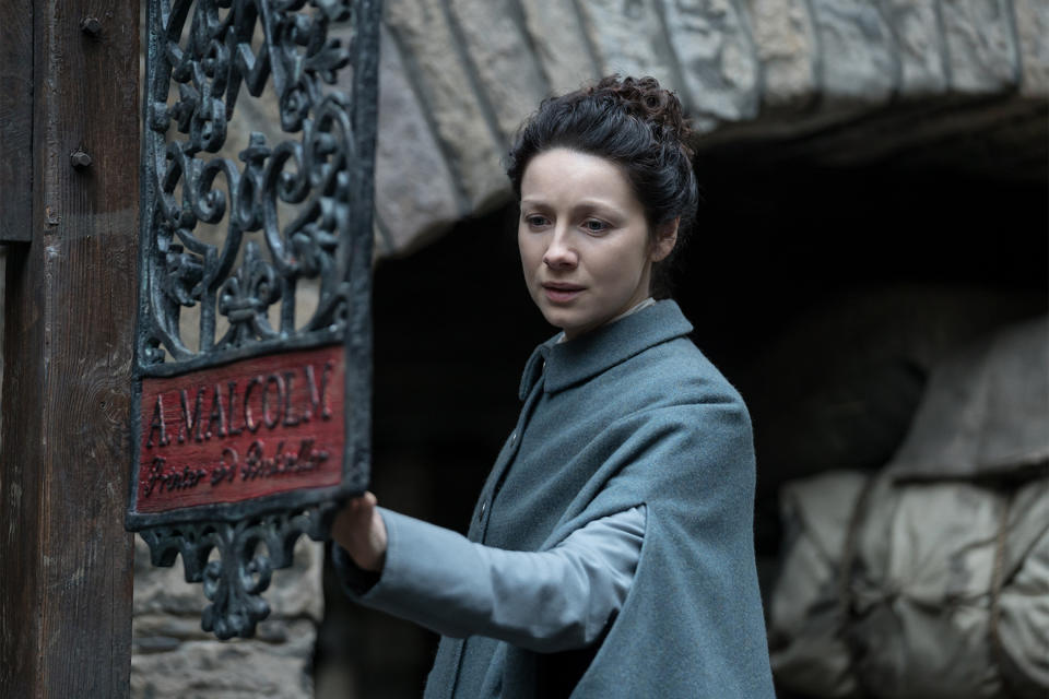 Claire examines the sign for A. Malcolm’s print shop (Photo: Starz)