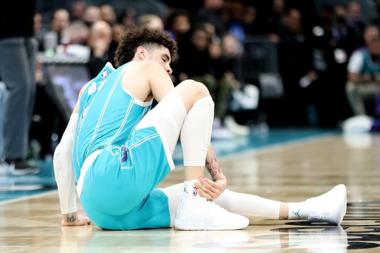 LaMelo Ball #1 of the Charlotte Hornets holds his ankle after an apparent injury during the second half of a basketball game against the Detroit Pistons at Spectrum Center on February 27, 2023 in Charlotte, North Carolina.