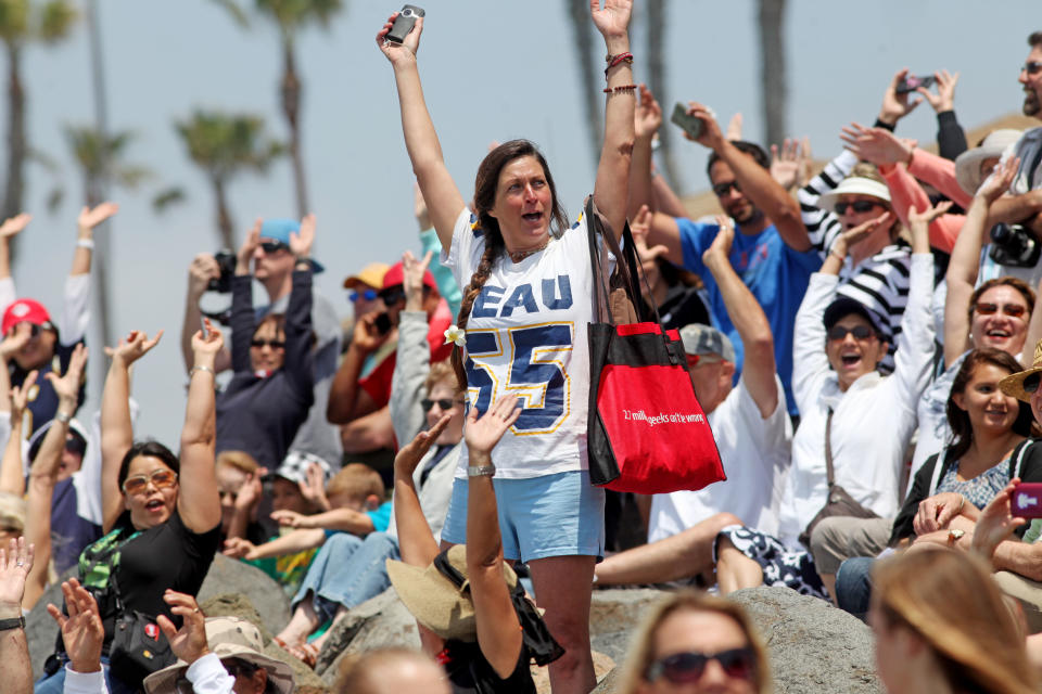 OCEANSIDE, CA - MAY 6: Bryn Best waves to surfers in the water during a "paddle-out" ceremony in honor of NFL star Junior Seau on May 6, 2012 in Oceanside, California. Seau, who played for various NFL teams including the San Diego Chargers, Miami Dolphins and New England Patriots was found dead in his home on May 2nd of an apparent suicide. Family members have decided to donate his brain for research on links between concussions and possible depression. (Photo by Sandy Huffaker/Getty Images)