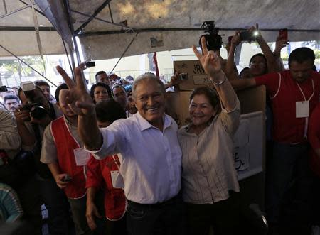 Salvador Sanchez Ceren (L), presidential candidate for the Farabundo Marti Front for National Liberation (FMLN) and his wife Margarita Villalta give victory signs at a polling station during the presidential elections in San Salvador February 2, 2014. REUTERS/Henry Romero