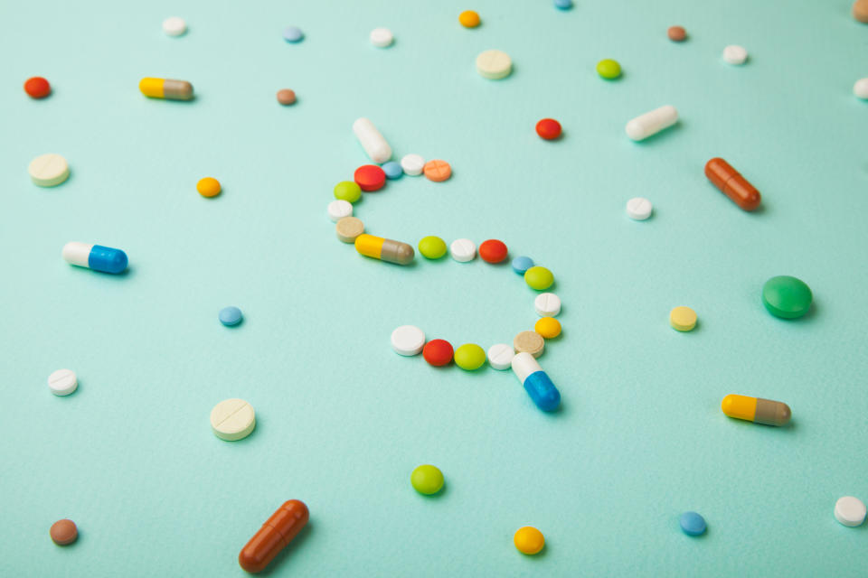 Pills arranged in the shape of a dollar sign.