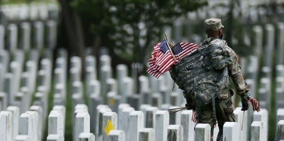 Soldiers from the 3rd Infantry Regiment, also called the "Old Guard," place US flags in front of every grave site in Arlington National Cemetery.