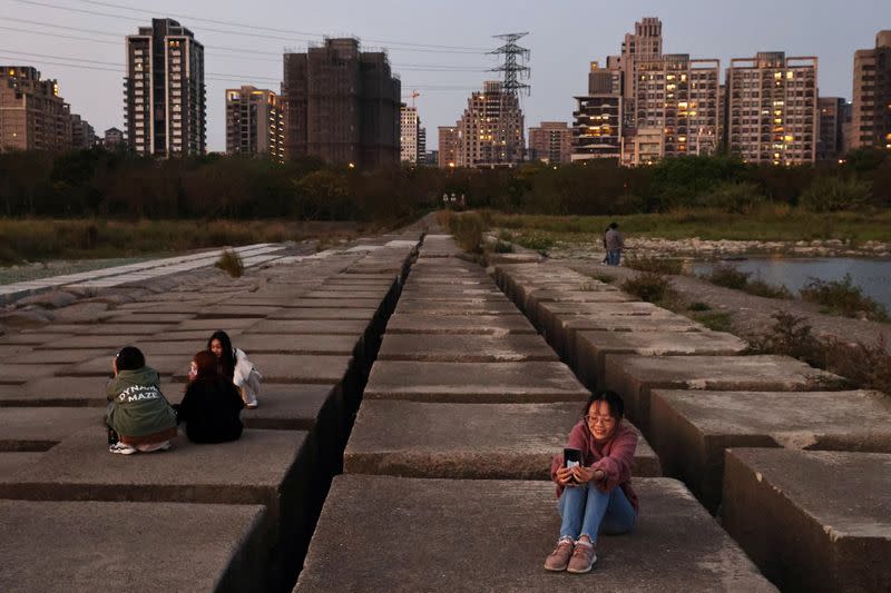 People take photos on the exposed riverbed of Touqian river in Hsinchu