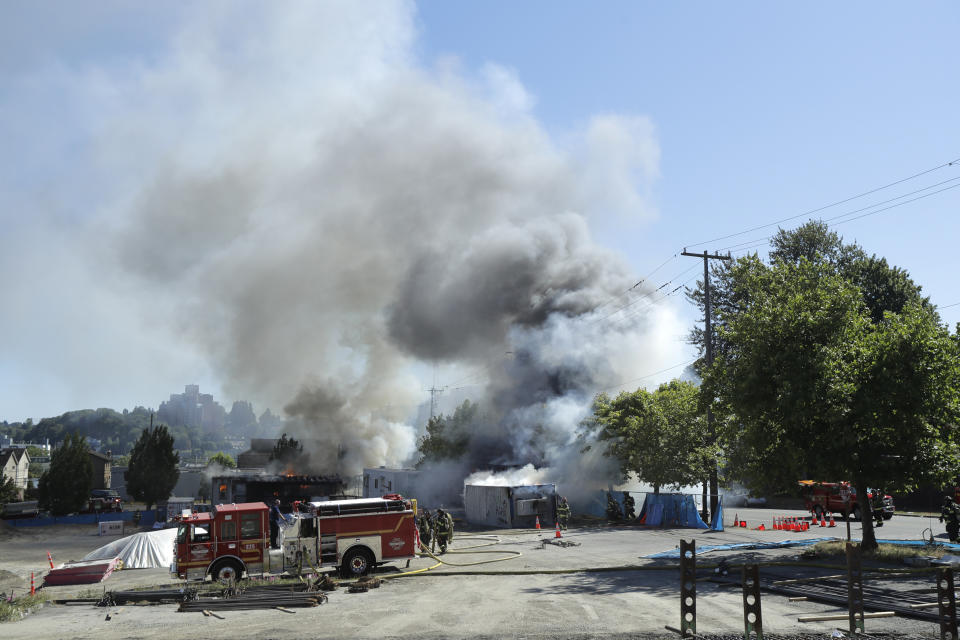 Construction buildings burn near the King County Juvenile Detention Center, Saturday, July 25, 2020, in Seattle, shortly after protesters left the area. A large group of protesters were marching Saturday in Seattle in support of Black Lives Matter and against police brutality and racial injustice. Protesters broke windows and vandalized cars at the facility. (AP Photo/Ted S. Warren)