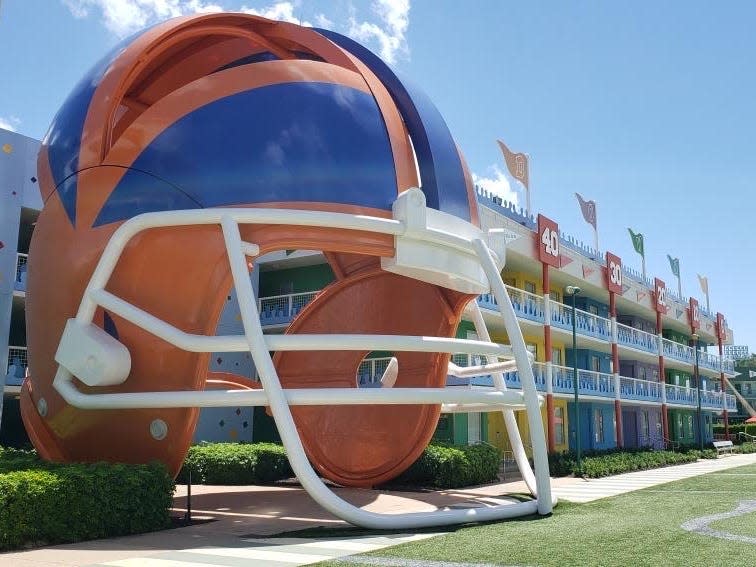 exterior shot of a big football helmet statue in front of a field at disney's all star sports resort
