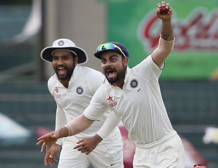 India's captain Virat Kohli (R) celebrates with Rohit Sharma after taking the catch to dismiss Sri Lanka's Dinesh Chandimal (not pictured) during the fourth day of their third and final test cricket match in Colombo, August 31, 2015. REUTERS/Dinuka Liyanawatte