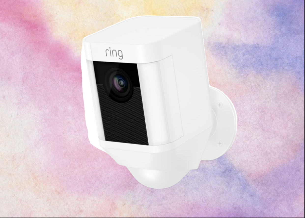 White Ring Spotlight HD Security Camera on a pink and purple marbled background