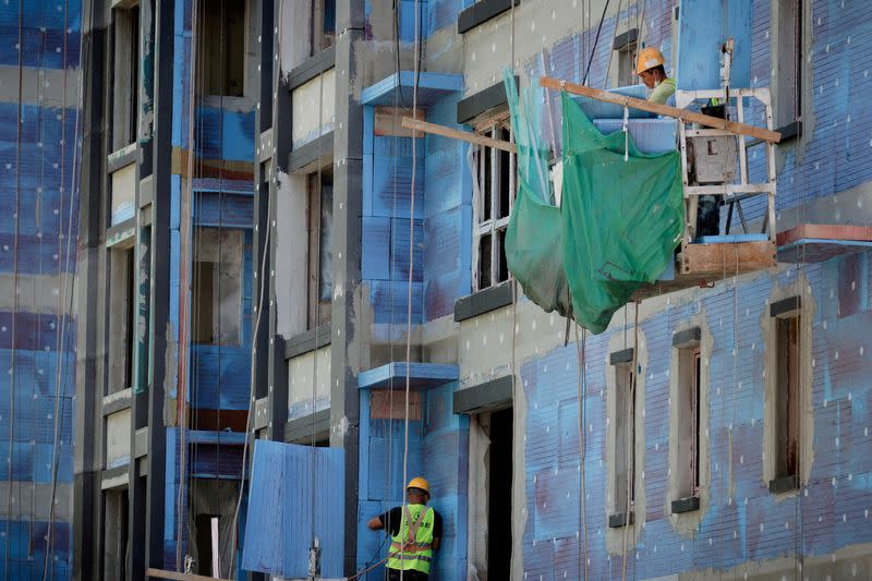 FILE PHOTO: Men work at a construction site of apartment buildings in Beijing