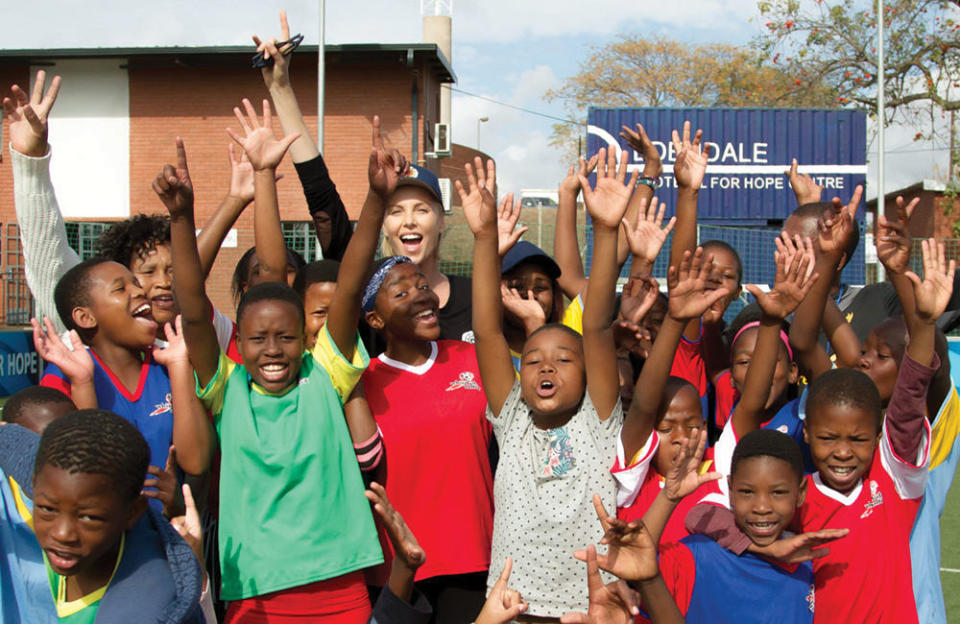 Charlize Theron in the field for the Charlize Theron Africa Outreach Project, which helps African youths keep safe from HIV/AIDS. - Credit: Leigh Page/Courtesy Of EIF