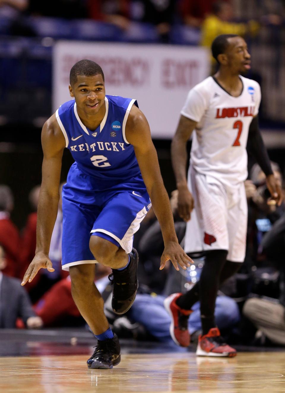 Kentucky's Aaron Harrison celebrates after making a three-point basket in front of Louisville's Russ Smith during the second half of an NCAA Midwest Regional semifinal college basketball tournament game Saturday, March 29, 2014, in Indianapolis. (AP Photo/Michael Conroy) 