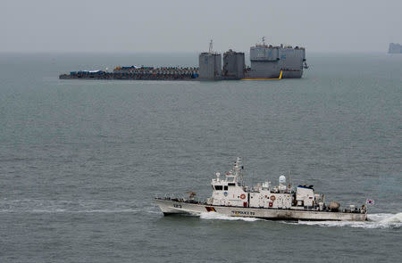 Barges are seen during a salvage operation of sunken ferry Sewol at the sea off Jindo, South Korea, March 22, 2017. News1 via REUTERS