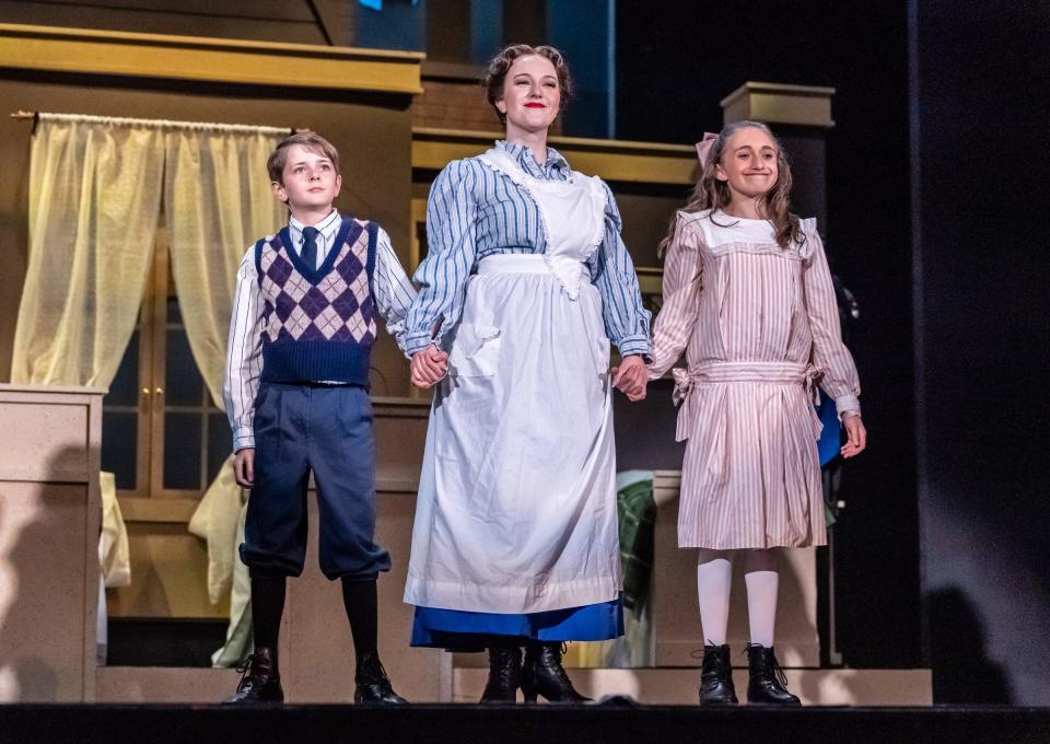 Amber Woollcott as Mary Poppins is flanked by Adrian Stukey and Sophia Bernard as Michael and Jane Banks in a scene from “Mary Poppins” at the Croswell Opera House.