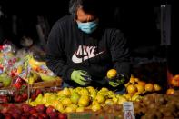 A man wears a mask and gloves as he shops at a fruit stand, during the outbreak of the coronavirus disease (COVID-19), in Brooklyn, New York